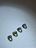 four small briolette cut sapphires on neutral background