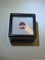 Oval pink tourmaline in display box, top view