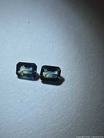 Pair of rectangular bi-colored sapphires on neutral background