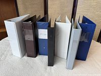 All eight binders standing upright to show spines and colours