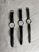 Front view of three wristwatches showing dials and straps