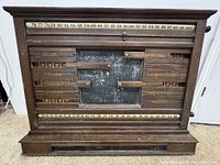 Front view showing entire wooden scoreboard, labels, numeric rails, chalkboard, knobs
