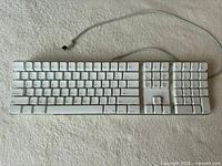 Top view showing full Apple keyboard layout and cable