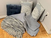 Group shot of blanket, throw, two decorative pillows, seat cushion, and pillowcases