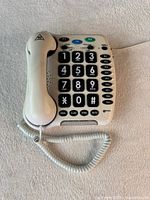 Front view showing big button keypad, handset, coiled cord