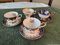 Group of four teacups with three saucers displayed together