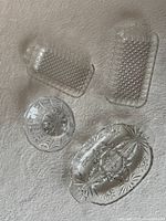 Four clear glass serving dishes on surface