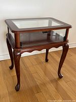 Full view of wood and glass display side table front angle