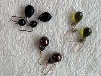 All three pairs of drop earrings displayed on fabric