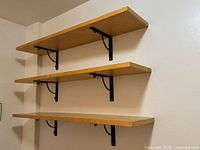 Full view of three stacked shelves mounted on wall
