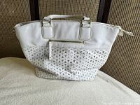 Front view showing triangular cutout design, handles, front zip pocket