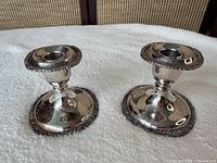 pair of matching silver-plated candlesticks front view