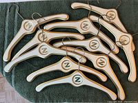 Overview of all twelve white and gold wooden hangers with Z monogram