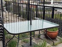 full view of glass-top table with umbrella pole and base weight