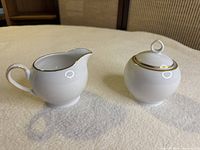 creamer and sugar bowl side view showing shape and gold rim