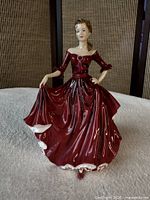 Front view of Royal Doulton "Kate" figurine in burgundy dress