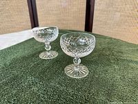 Two Waterford Boyne crystal saucer champagne glasses side by side on green cloth