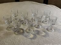 Group of nine cut crystal cordial glasses on cloth background