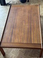 Top view of teak coffee table showing grain and raised edge rails