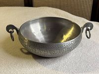 Top angled view of pewter bowl showing dragon head handles and textured exterior