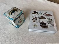 Square decorative tin and Hudson's Bay Company flat tin side by side