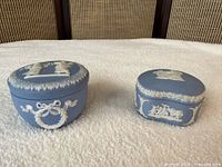 Both blue jasperware trinket boxes showing lids and side reliefs