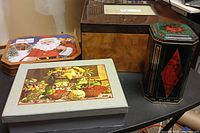 Group view of four containers: Santa tin, fruit keepsake box, veneer jewelry box, geometric tin