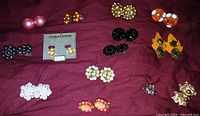Wide view of all earring pairs on burgundy cloth