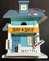 Front view showing Surf Shop sign, veranda, tags, colors