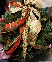 Front view of wreath showing ribbons, pinecones and ornaments