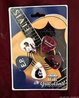 Front of sealed card displaying five guitar picks on guitar background