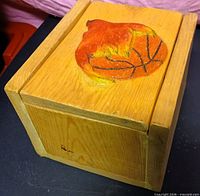 Closed wooden box showing carved painted motif on lid