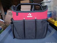 Front view of Husky red/black canvas tool tote with metal handle and exterior pockets