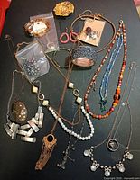 Overview of mixed jewelry pieces spread on black surface