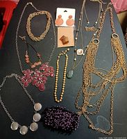 All jewelry pieces laid out including necklaces, earrings on cards, beaded bracelet