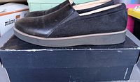 Side view of black loafers on box