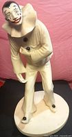 Front view of plaster Pierrot clown figurine on round base