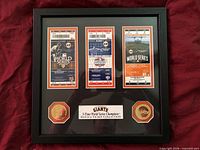 Full view of framed memorabilia showing tickets, coins and plaque