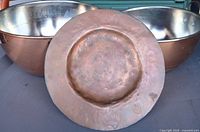 Two tin-lined copper bowls and engraved plate displayed together