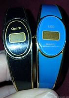 Front view of both watches showing LCD windows and colors