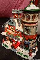 Front angled view of ceramic fire station showing façade, tower, fire truck and snow accents