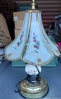 Full view of lamp showing base, porcelain accent and glass shade