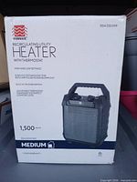 Front of retail box showing WarmWave 1,500 W recirculating utility heater image and specifications