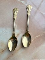 Two gold-tone Rogers spoons side by side showing overall design