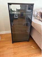 Front view of black glass door media cabinet