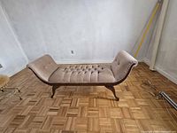 Side view of upholstered bench showing full length and wooden legs