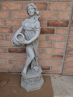 Full front view of plaster female statue on octagonal base