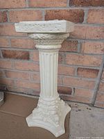 Full view of ceramic column plant stand showing fluted shaft and ornate base