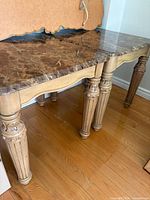 Pair of side tables showing marble top and wood base