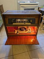 Front view of NordMende console showing radio dial, knobs, drop-down door open revealing turntable
